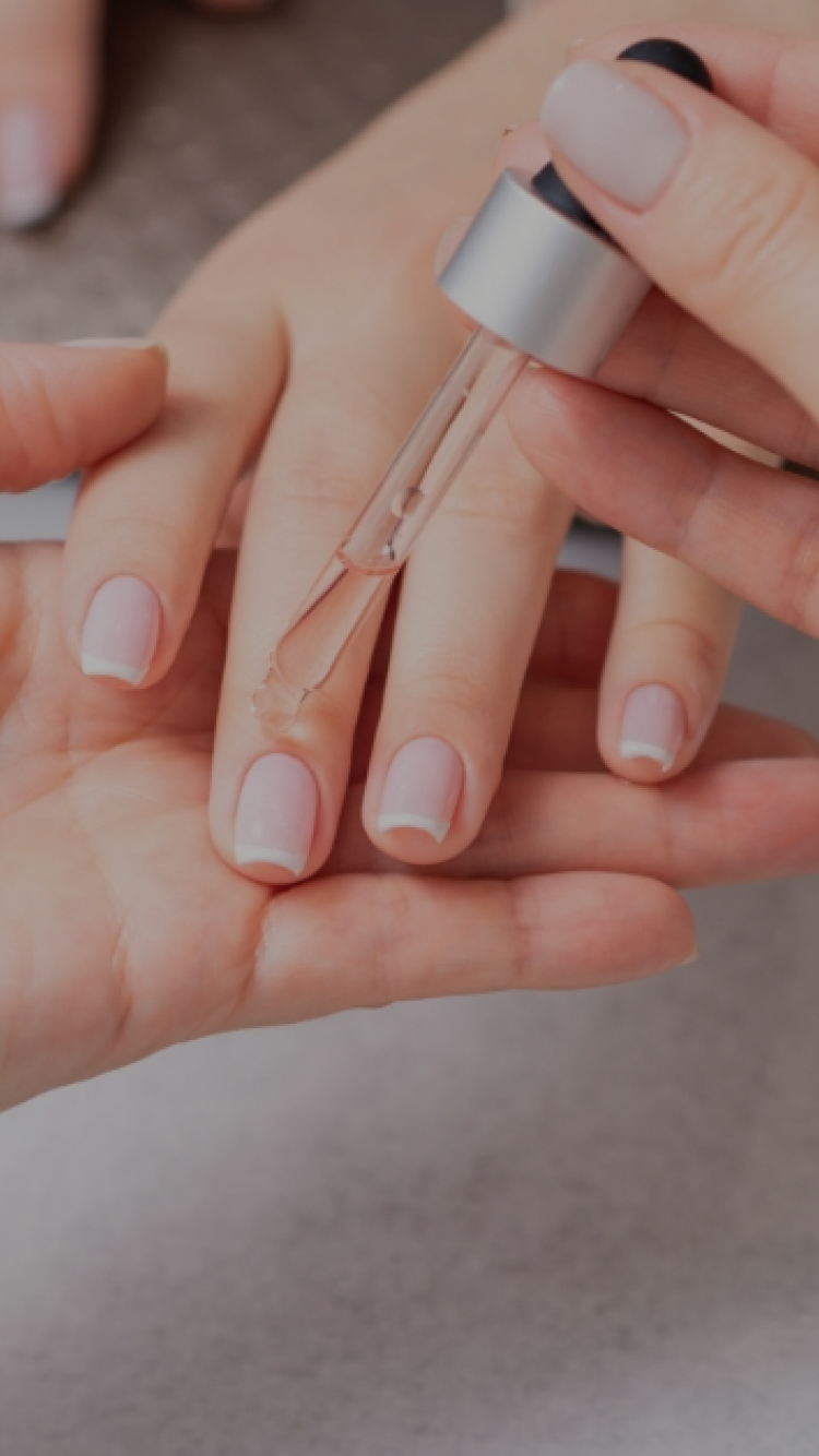 スポイトを使って爪先にネイルオイルを塗布し、丁寧にケアをしている様子